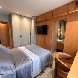 Quarto com cama e painéis de madeira em um imóvel.