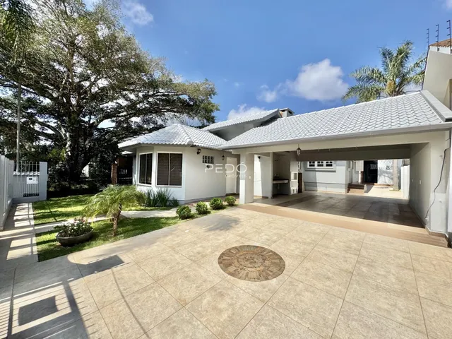Fachada de uma casa em Lajeado, Brasil com jardim e área externa pavimentada.
