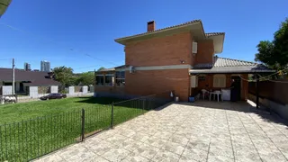 Foto da fachada de uma casa de tijolos com jardim em Lajeado, Brasil.