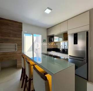 Vista da cozinha com armários modernos e bancada de vidro.