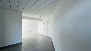 Um corredor longo com paredes brancas e piso de cerâmica.
