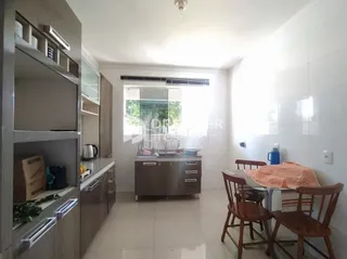 Vista interna de uma cozinha com armários e janela em um imóvel no Brasil.