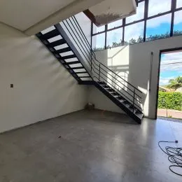 Foto de um espaço interno com escadaria e grandes janelas.