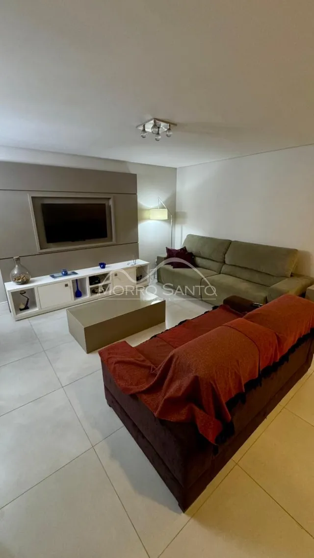 Sala de estar com sofá e televisão em um apartamento.
