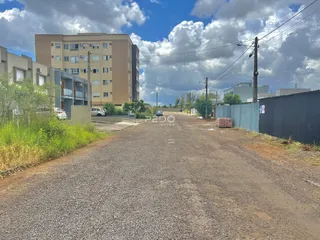 Vista externa de um imóvel em Lajeado, Brasil, mostrando uma rua de terra e um prédio residencial ao fundo.