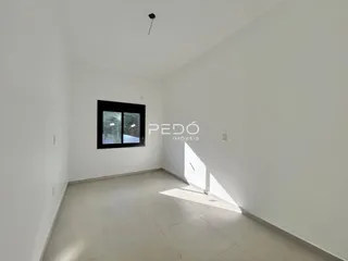 Ambiente interno de uma sala com paredes brancas e piso claro.