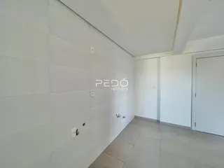 Vista interna de um corredor com paredes brancas e piso claro.