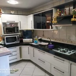 Foto de uma cozinha com armários superiores e inferiores e bancadas.