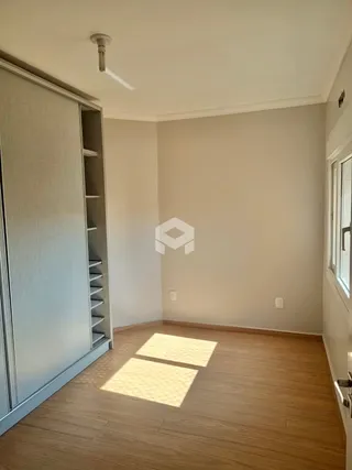 Vista interna de um cômodo com piso de madeira clara e paredes brancas.