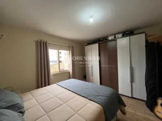 Quarto com cama e armário de madeira em um imóvel no Brasil.