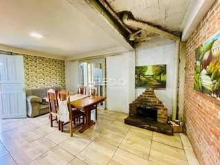 Ambiente interno de sala de jantar com piso de cerâmica e parede de tijolos aparentes.