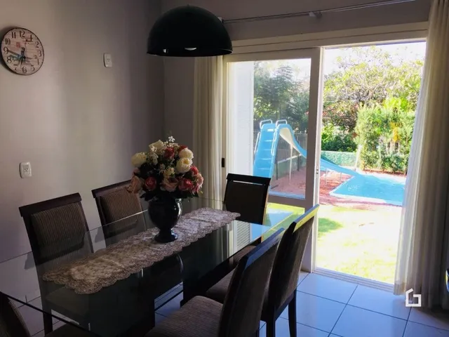Sala de jantar com vista para o quintal através de portas de vidro.