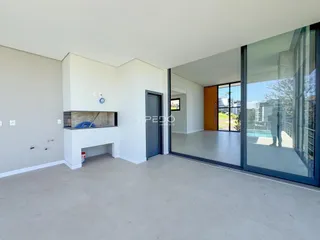 Ambiente interno de uma sala ampla com piso de concreto e porta de vidro.