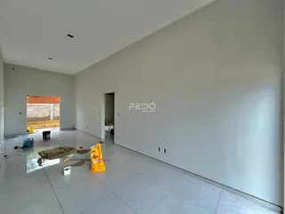 Espaço interno vazio com piso de cerâmica e paredes brancas.