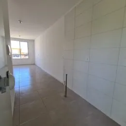 Hall de entrada com paredes brancas e piso claro.
