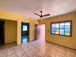 Hall de entrada com piso de cerâmica e paredes amarelas em uma residência.