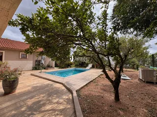 Vista externa de uma piscina e deck em uma propriedade.