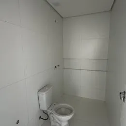 Foto interna de um banheiro simples com vaso sanitário.