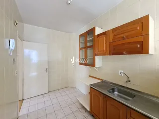 Interior de um cômodo com armários em madeira e piso cerâmico.