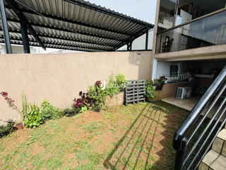 Vista externa de um jardim com vegetação e muro em Lajeado, Brasil.
