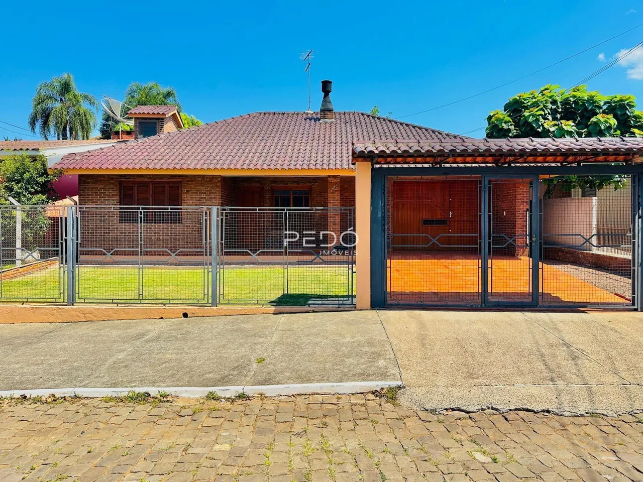 Vista da fachada de uma residência em Lajeado, Brasil, com cerca e garagem.