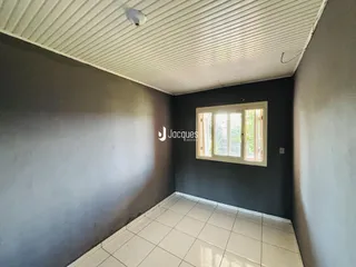Vista interna de um cômodo com paredes cinzas e piso claro.