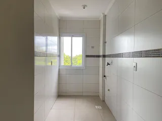 Corredor interno com paredes brancas e piso de cerâmica.