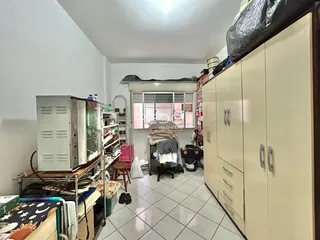 Imagem de um cômodo interno com armários e móveis no piso de cerâmica.
