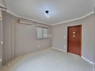 Uma sala de estar com paredes cinzas e piso claro.