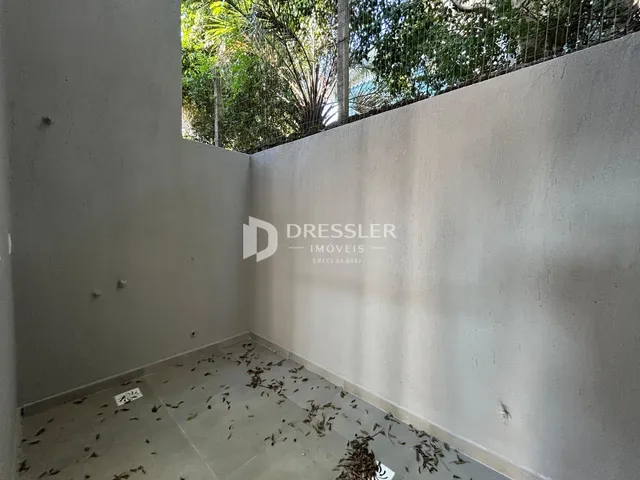 Vista interna de um cômodo com paredes brancas e piso de cerâmica.