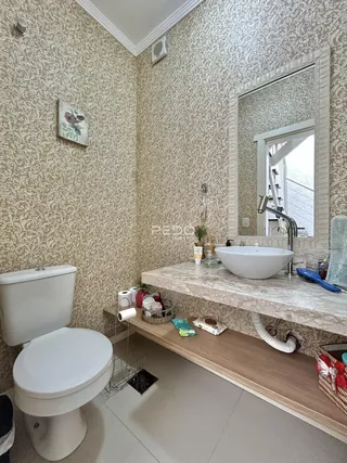 Banheiro com revestimento de papel de parede e bancada de mármore.