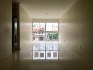 Corredor interno de uma residência com grande janela.