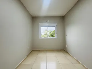 Vista interna de um cômodo com paredes claras e piso de cerâmica.