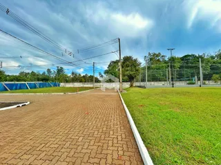 Vista externa do terreno com cerca e gramado.