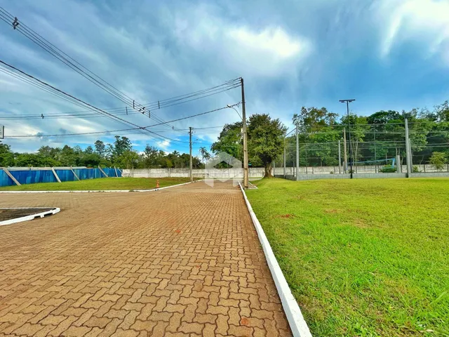 Vista externa do terreno com cerca e gramado.