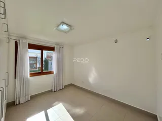 Interior de uma sala com piso de cerâmica e janela.