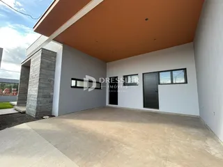 Vista de uma área externa com paredes em tons de cinza e branco.