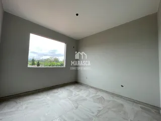 Sala de estar com piso de porcelanato claro e grande janela.