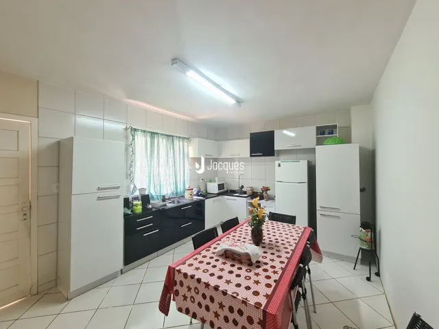 Ambiente interno de uma sala com revestimento de cerâmica e armários brancos.