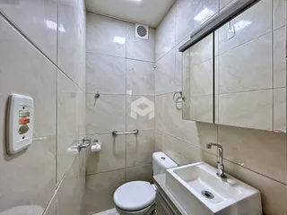 Foto de um banheiro com revestimento cerâmico nas paredes.