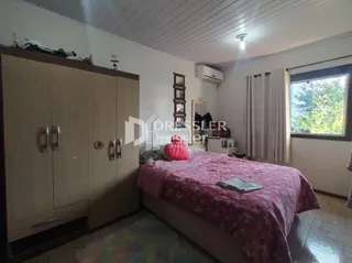 Quarto com cama e armário de madeira em um imóvel no Brasil.