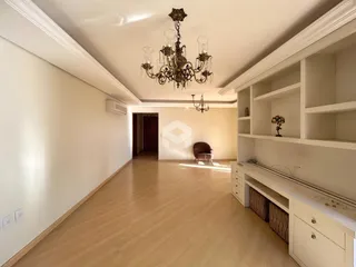 Sala de estar com piso de madeira e lustre de cristal.