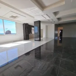 Ambiente interno moderno com piso escuro e teto claro.