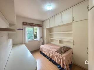 Foto de um quarto com armários brancos e piso de madeira.