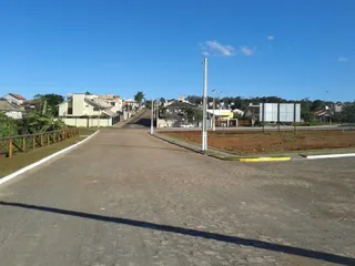 Vista externa de uma rua residencial em Lajeado, Brasil, com casas ao fundo.