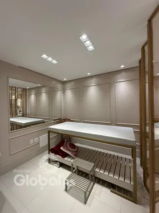Quarto moderno com cabeceira de madeira e espelho.