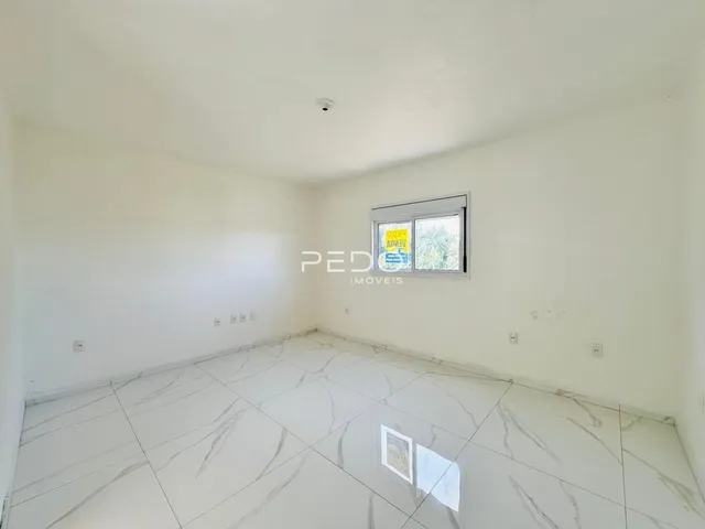 Ambiente interno de uma sala com piso de mármore branco.