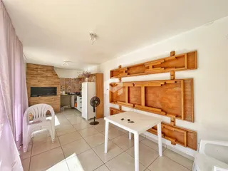 Interior de uma sala de estar com detalhes em madeira e piso cerâmico.