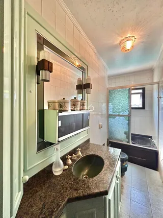 Vista de uma bancada de cozinha com pia e revestimento de azulejo na propriedade.