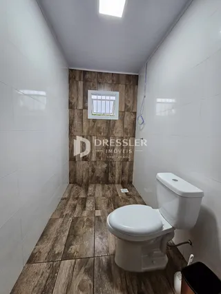 Foto de um banheiro com piso de madeira e parede de destaque em um imóvel no Brasil.